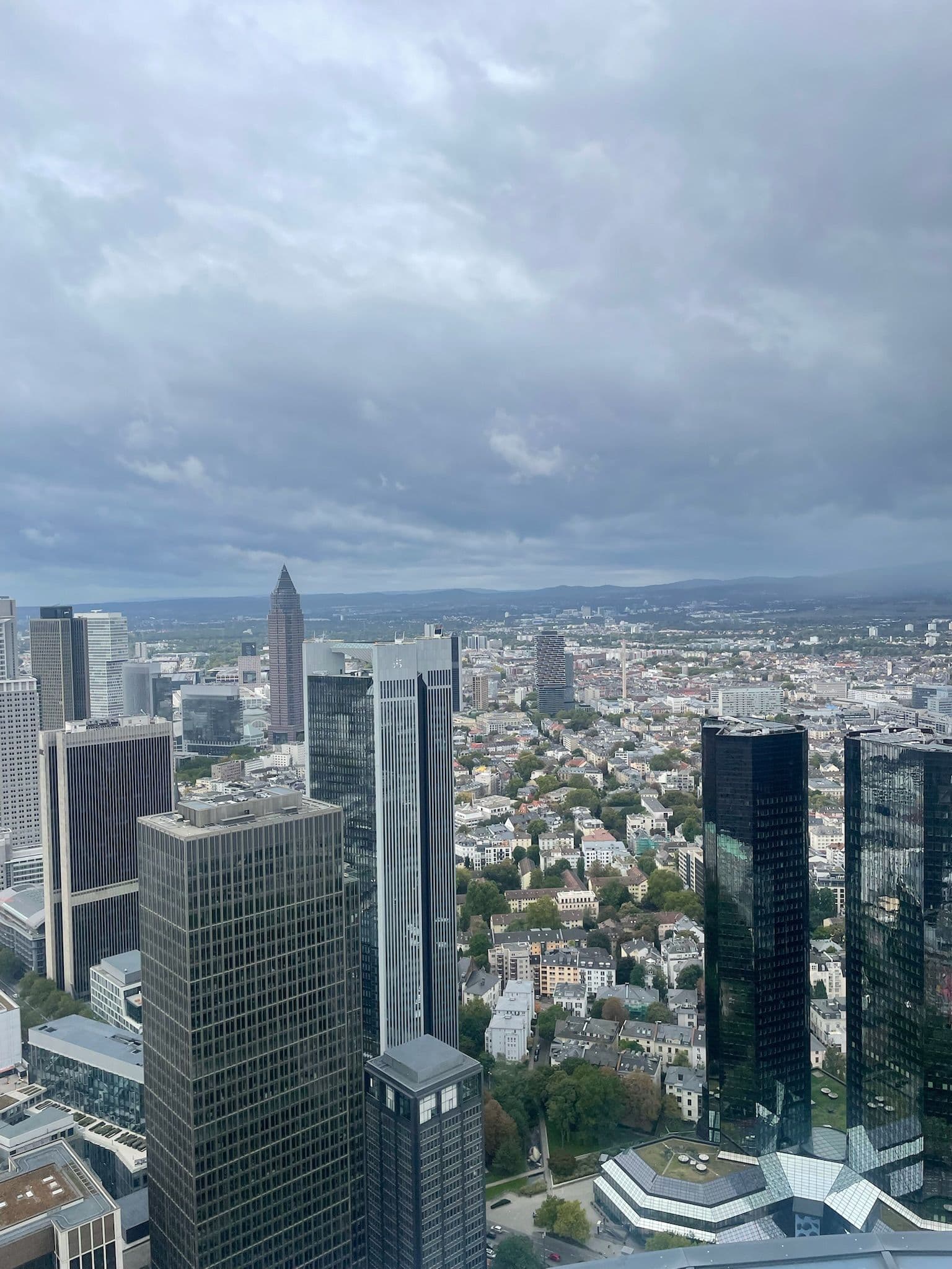 Stadtansicht von Frankfurt mit Wolkenkratzern unter bewölktem Himmel.