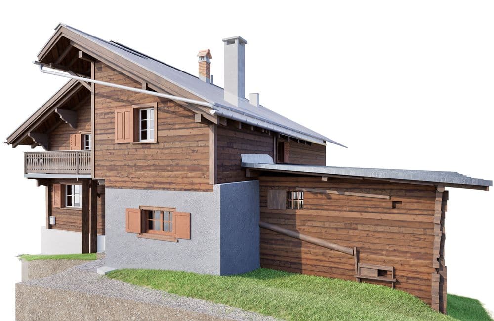 Ein traditionelles Holzchalet auf einem grasbewachsenen Hügel, mit Fensterläden und einem Balkon.