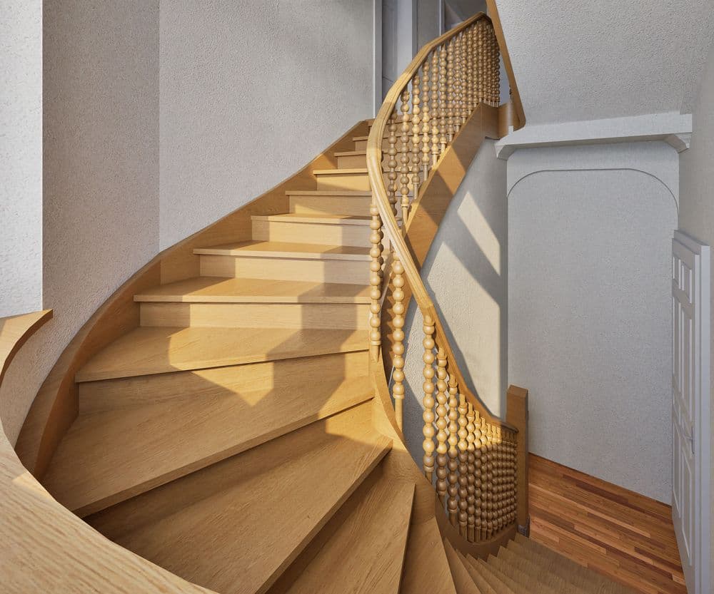 Holzwendeltreppe mit kunstvollem Geländer in elegantem Innenraum.