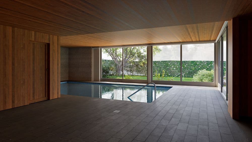 Ein eleganter Innenpool mit Holzwänden und großen Fensterfronten, die den Blick ins Grüne freigeben.