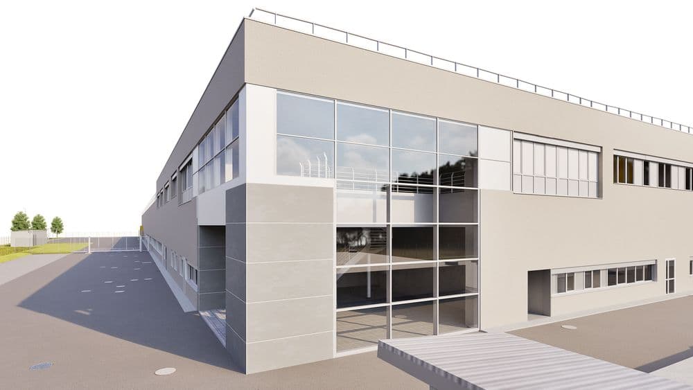 Modernes Industriegebäude mit großen Glasfenstern und grauer Fassade.