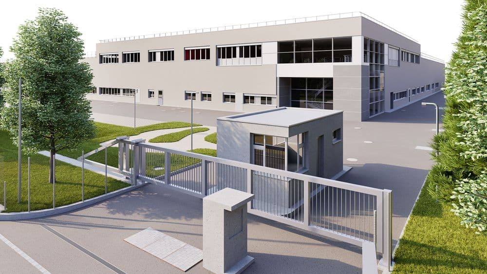 Modernes Industriegebäude mit Bürotrakt, Vorgarten und Eingangstor.