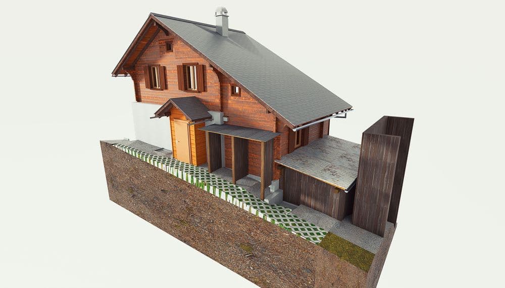 Ein zweistöckiges Holzhaus auf einem Hang, mit grauem Dach und einer Garage.