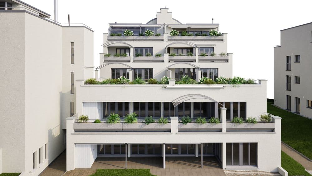 Ein modernes mehrstöckiges Gebäude mit großen Fensterfronten und begrünten Terrassen, umgeben von weiteren Wohnhäusern.