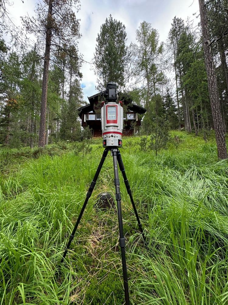 Vermessungsgerät im Wald auf Stativ.